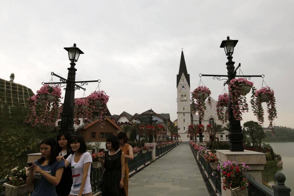 Women walk at the Chinese replica of Austria's UNESCO heritage site, Hallstatt village in China's southern city of Huizhou in Guangdong province