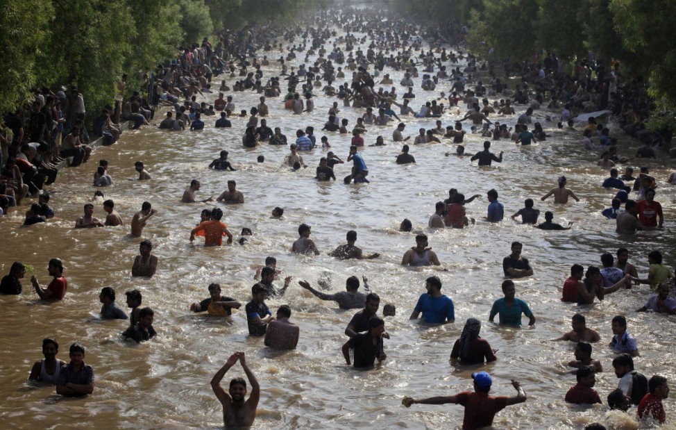 Men cool down in a canal in the eastern city of Lahore
