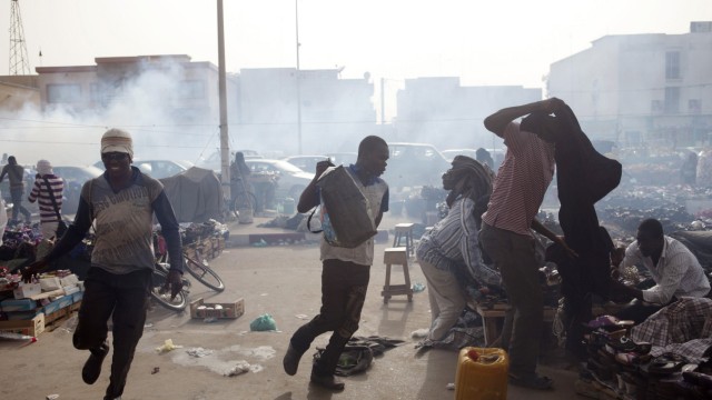 Men run from tear gas fired by police during an anti-slavery demonstration to demand the liberation of imprisoned abolitionist leader Biram Ould Abeid in Nouakchott
