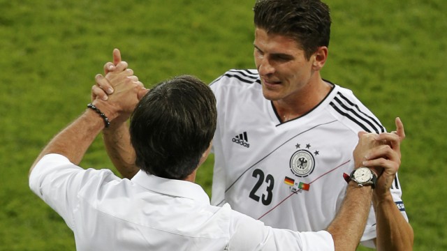Germany's Gomez celebrates with coach Loew after scoring against Portugal during their Group B Euro 2012 soccer match at the new stadium in Lviv