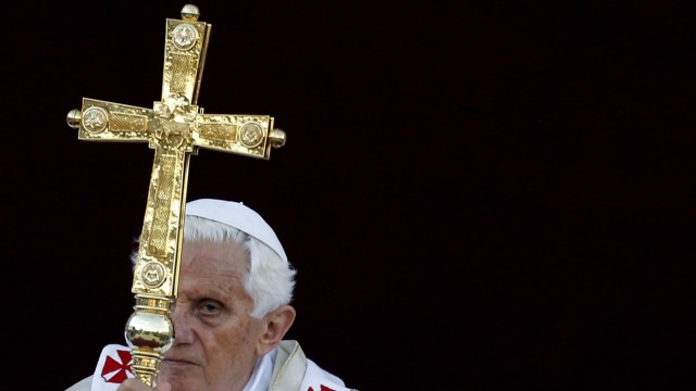 Pope Benedict XVI holds the cross as he leads the Corpus Domini mass in Rome's Basilica of St. John in Lateran