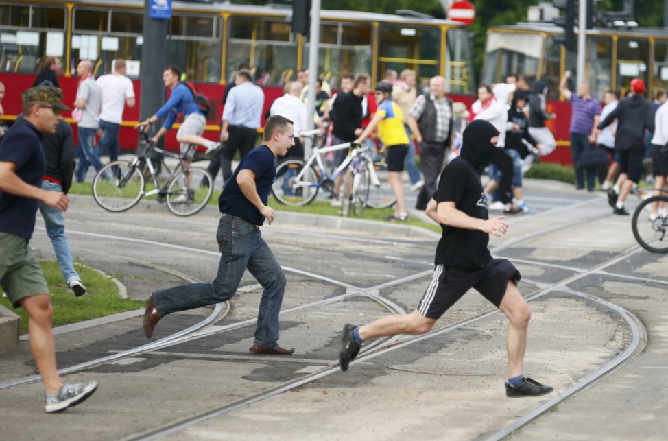 Soccer fans run during clashes before Euro 2012 soccer match between Poland and Russia in Warsaw