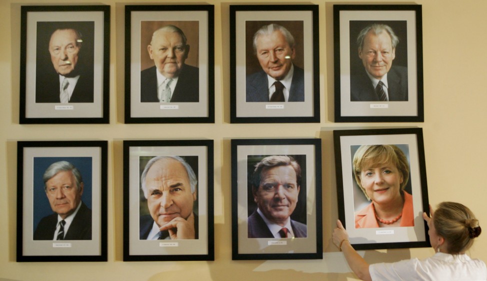 Restaurant manager places a portrait  of new German Chancellor Merkel on a wall at the restaurant 'Kanzlereck' in Berlin