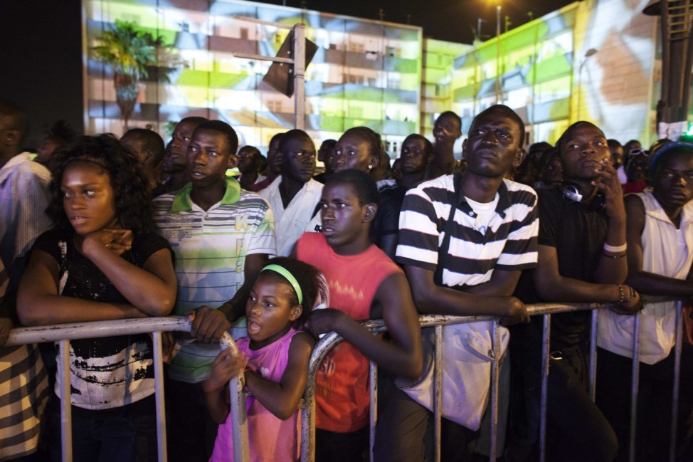A crowd watches a street fashion show marking the opening night of Dakar Fashion Week