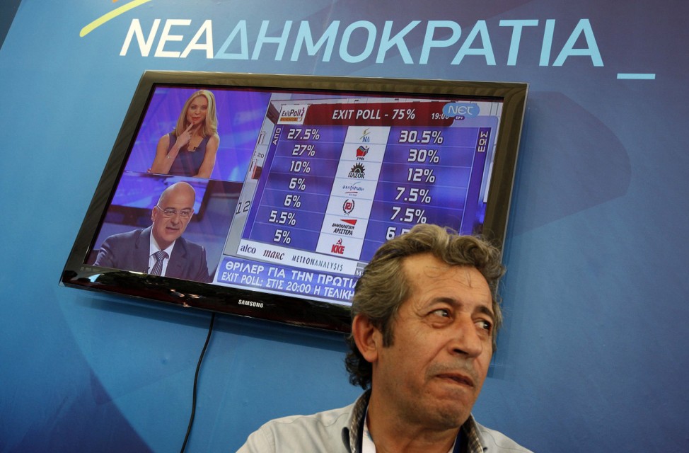 Conservative New Democracy supporter is seen before television screen showing exit polls in main New Democracy campaign center in Athens' Syntagma square