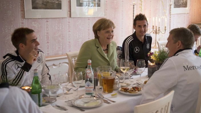 German Chancellor Merkel speaks with the captain of the German national soccer team Lahm, Klose and Schweinsteiger during a dinner in the team's Euro 2012 headquarters in Sopot