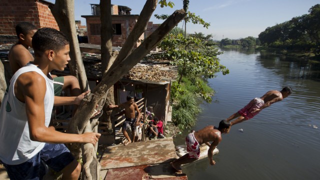 Rio de Janeiro und der UN-Gipfel: Teenager aus dem Slum Manguinhos in Rio de Janeiro baden im Jacare, einem der am stärksten verschmutzten Flüsse Brasiliens.