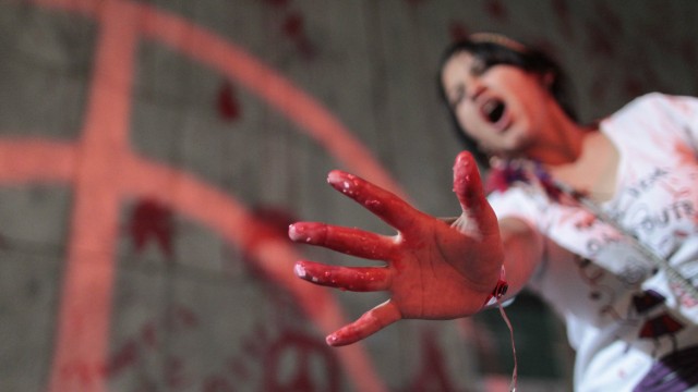 A protester shows her hand with red paint during a demonstration where they threw red paint on the wall of the building belonging to Brazil's Vale SA mining company, in Rio de Janeiro