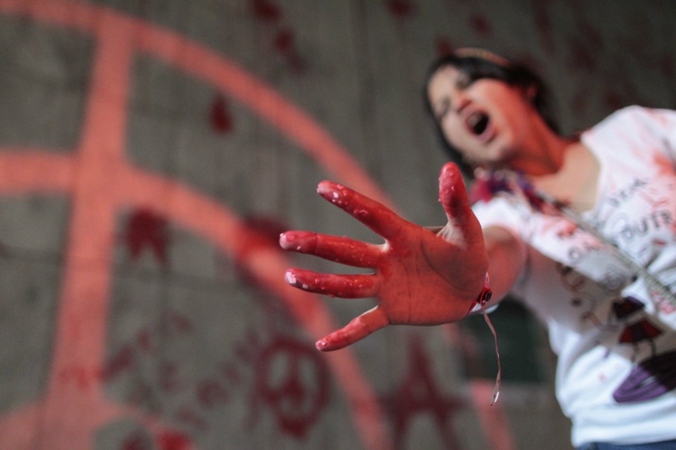 A protester shows her hand with red paint during a demonstration where they threw red paint on the wall of the building belonging to Brazil's Vale SA mining company, in Rio de Janeiro