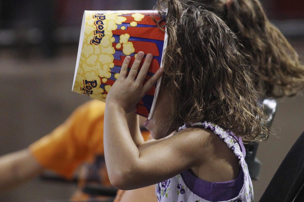 A young baseball fan makes sure there's not a kernel of popcorn left as she watches the Cubs play the Diamondbacks during their MLB National League baseball game in Phoenix