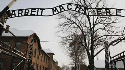 Gedenkstätte Auschwitz: Der Schriftzug "Arbeit macht frei" ist Symbol der Vernichtung und des Widerstandes.