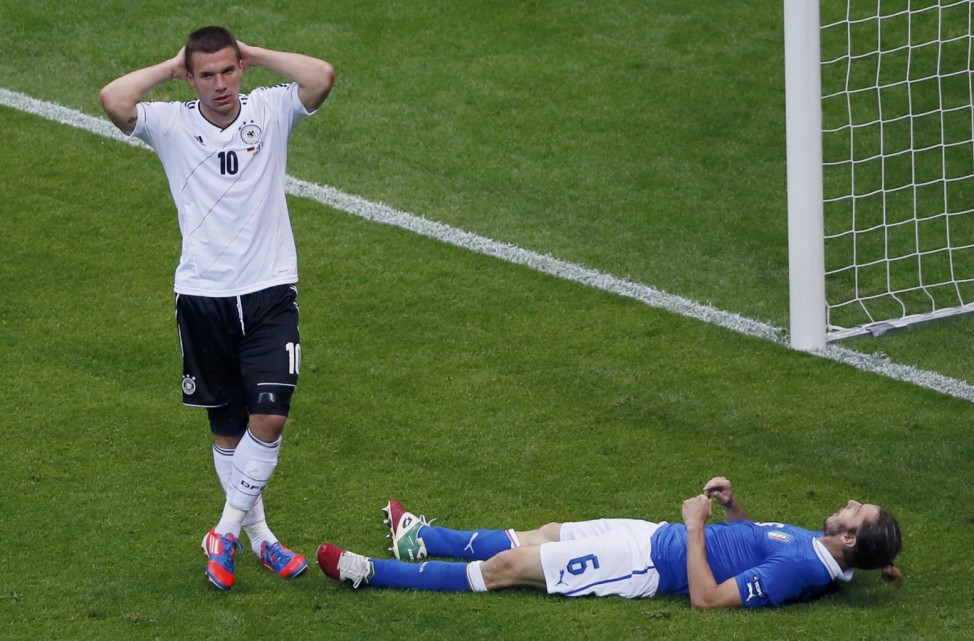 Germany's Podolski reacts next to Italy's Balzaretti during their Euro 2012 semi-final soccer match at National Stadium in Warsaw