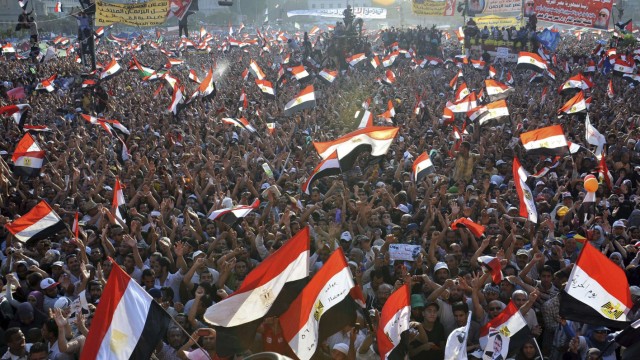 Supporters of Egypt's Islamist President-elect Mursi cheer during his speech in Cairo's Tahrir Square