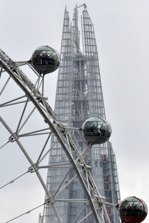The London Eye is seen in front of the Shard skyscraper in central London