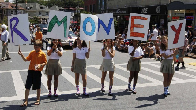 A group of young people parody U.S. Republican presidential candidate Romney's last name as R-MONEY as they march in a Fourth of July parade in Takoma Park