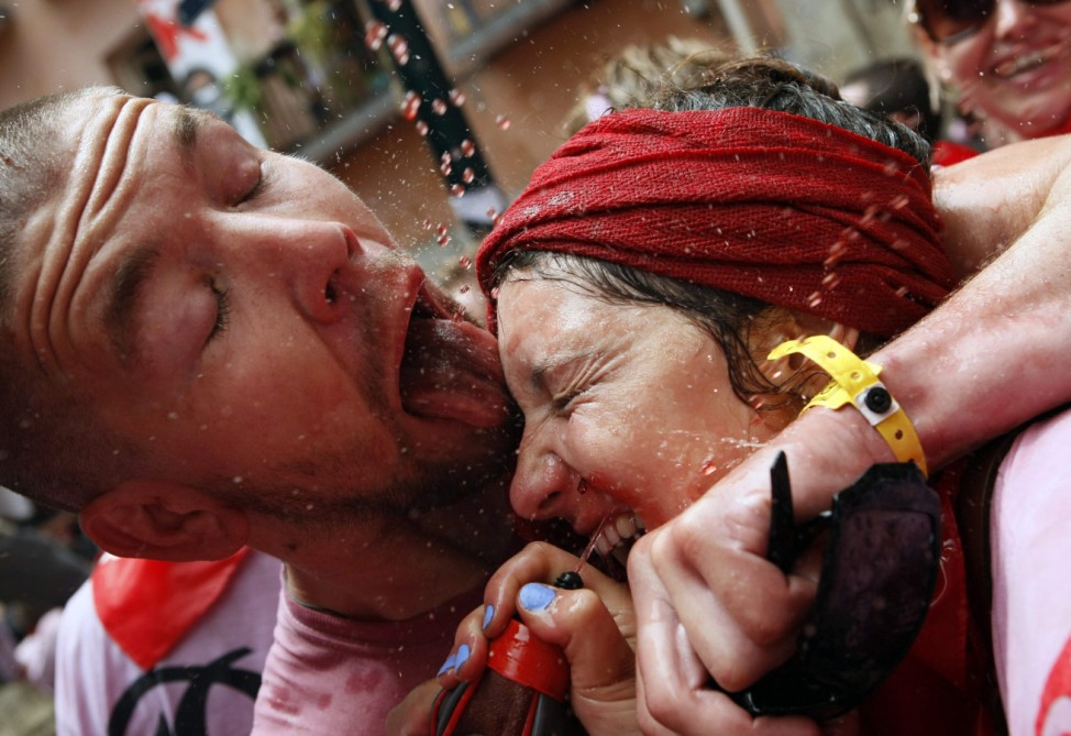 Revellers are sprayed with wine during the start of the San Fermin Festival in Pamplona