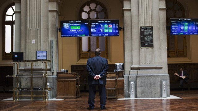 A trader looks at electronic boards at Madrid's stock exchange