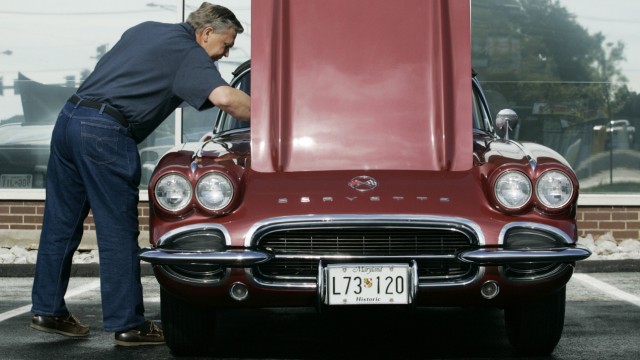 Larry Spillman checks under the hood of his 1962 Chevrolet Corvette at an antique car show at the Sport Chevrolet dealership in Silver Spring Maryland