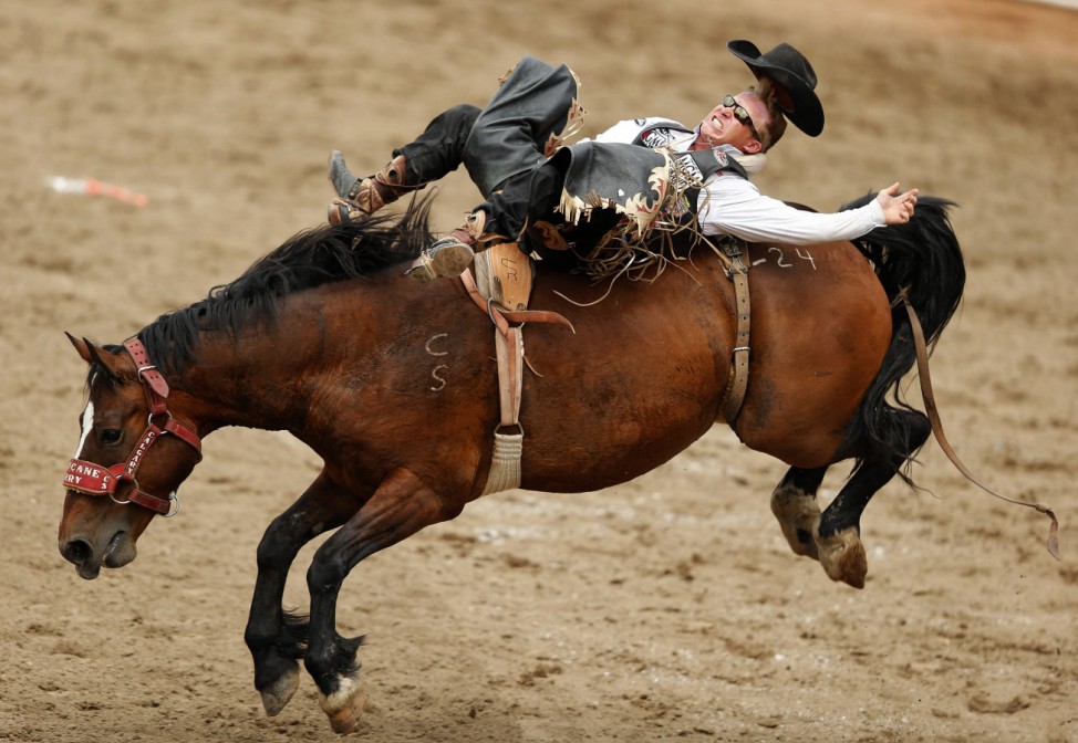 Stevenson loses his hat as he rides the horse Hurricane Terry in the bareback event during the 100th anniversary of the Calgary Stampede Rodeo in Calgary