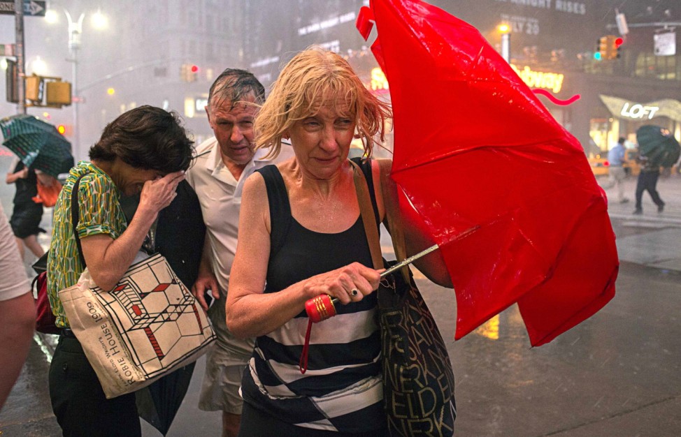 Commuters dodge high wind and heavy rain during a thunderstorm in midtown Manhattan