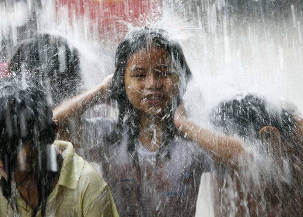 Children play in the rain during a sudden downpour brought by a low pressure area in Quezon City