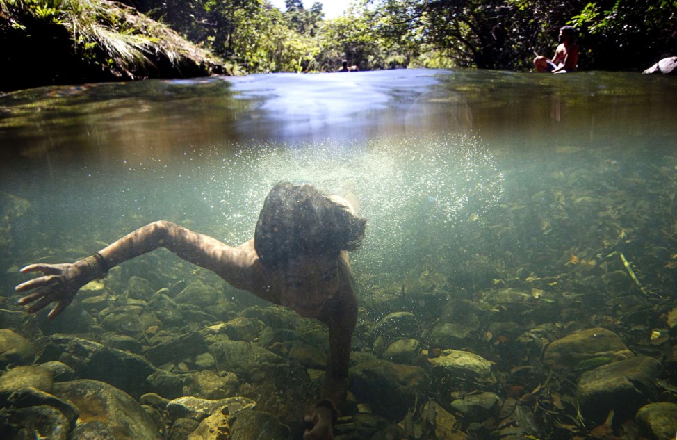 An indigenous child swims in the Sao Miguel River during the 'Meeting of Traditional Cultures of Chapada dos Veadeiros' in a multiethnic village in Goias