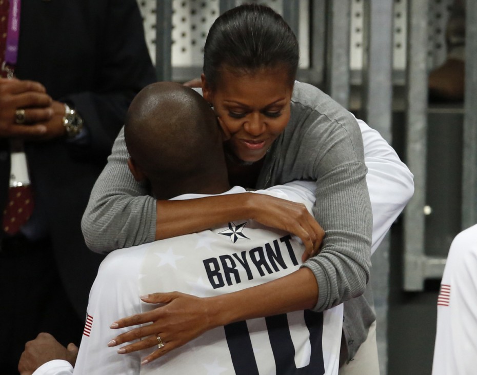 U.S. first lady Michelle Obama hugs U.S. basketball player Kobe Bryant at the end of a men's preliminary round basketball match in London