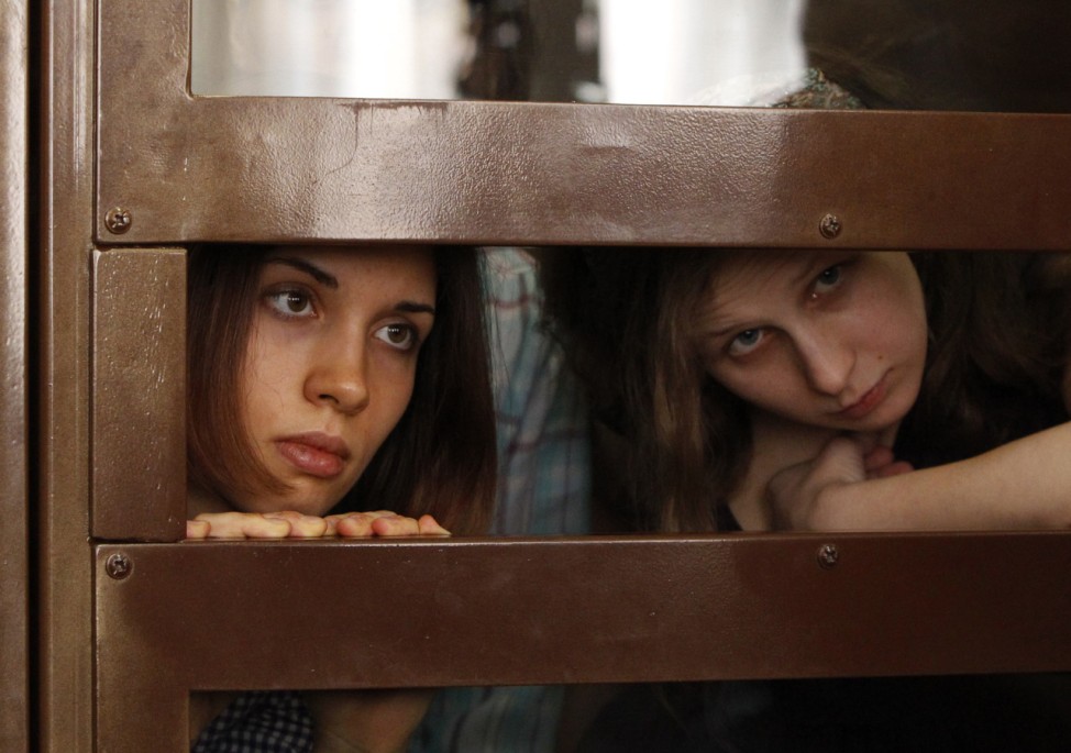 Tolokonnikova and Alyokhina, members of female punk band 'Pussy Riot', look out from the defendent's cell in a courtroom in Moscow