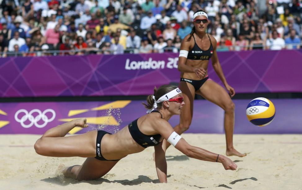 Germany's Katrin Holtwick tries to save the ball near her team mate Ilka Semmler during their women's preliminary round beach volleyball match at the London 2012 Olympic Games at Horse Guards Parade