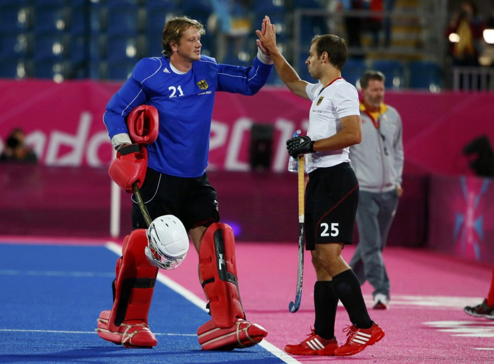 Germany's goalkeeper Max Weinhold and teammate Philipp Zeller celebrate their win over Belgium after their men's Group B hockey match at the London 2012 Olympic Games