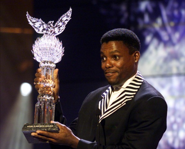 CARL LEWIS HOLDS UP THE TROPHY AT THE WORLD SPORTS AWARD CEREMONY IN VIENNA