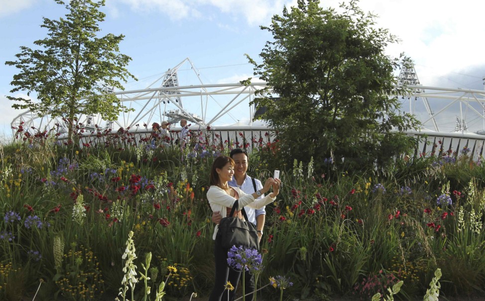 A couple from Hong Kong photograph themselves in front of the Olympic Stadium in Stratford, east London during the London 2012 Olympic Games