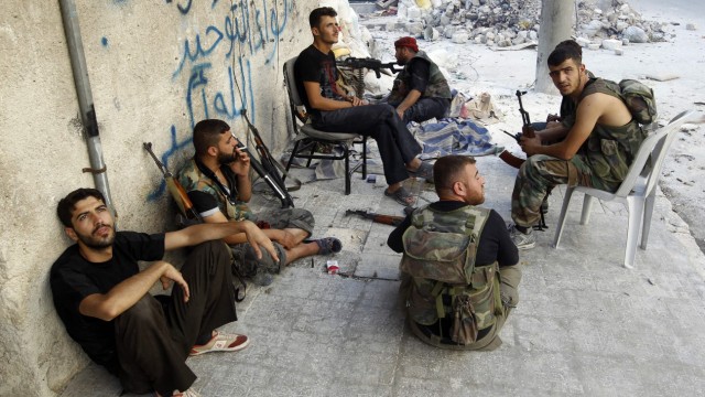 Free Syrian Army fighters take a break from fighting with forces loyal to Syrian President Assad in downtown Aleppo