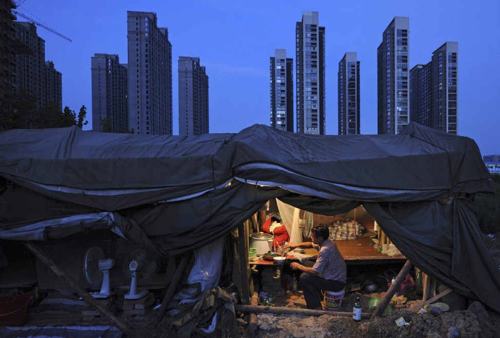 A labourer has his dinner under his shed at a construction site of a residential complex in Hefei