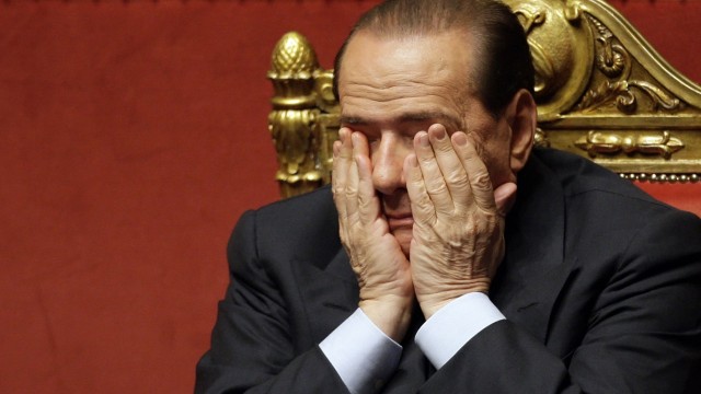 File picture shows Italian Prime Minister Berlusconi covering his face during a vote of confidence at the Senate in Rome