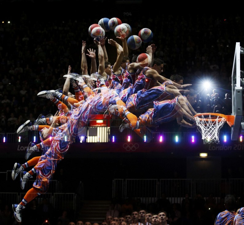 A member of the 'Crazy Dunkers' group performs a dunk during an interval of the men's preliminary round Group B basketball match between Australia and Russia at the Basketball Arena during the London 2012 Olympic Games