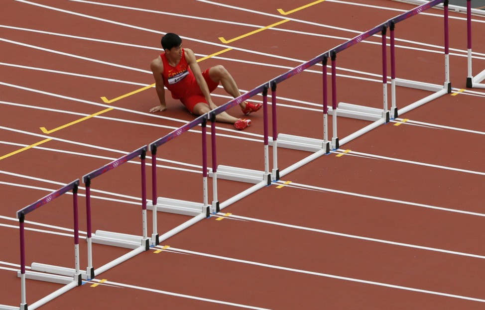 China's Liu Xiang holds his leg after suffering an injury during his men's 110m hurdles round 1 heat at the London 2012 Olympic Games at the Olympic Stadium