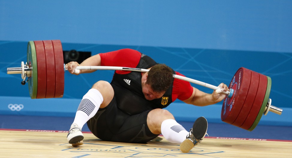Germany's Matthias Steiner is injured while his weights fall during the men's +105kg Group A snatch weightlifting competition during the London 2012 Olympic Games