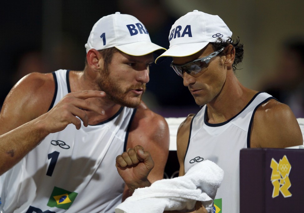 Brazil's Emanuel and Alison talk between sets during their men's beach volleyball gold medal match against Germany's Brink and Reckermann at Horse Guards Parade during the London 2012 Olympic Games