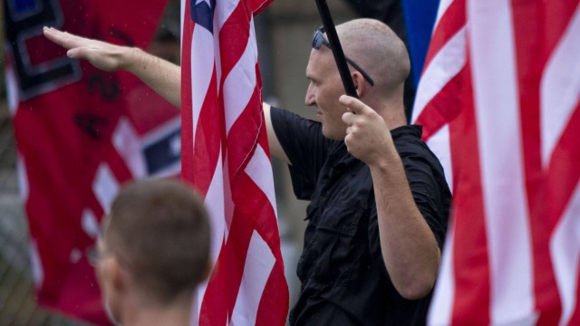 A member of a white supremacy group gives the fascist salute during a gathering in West Allis