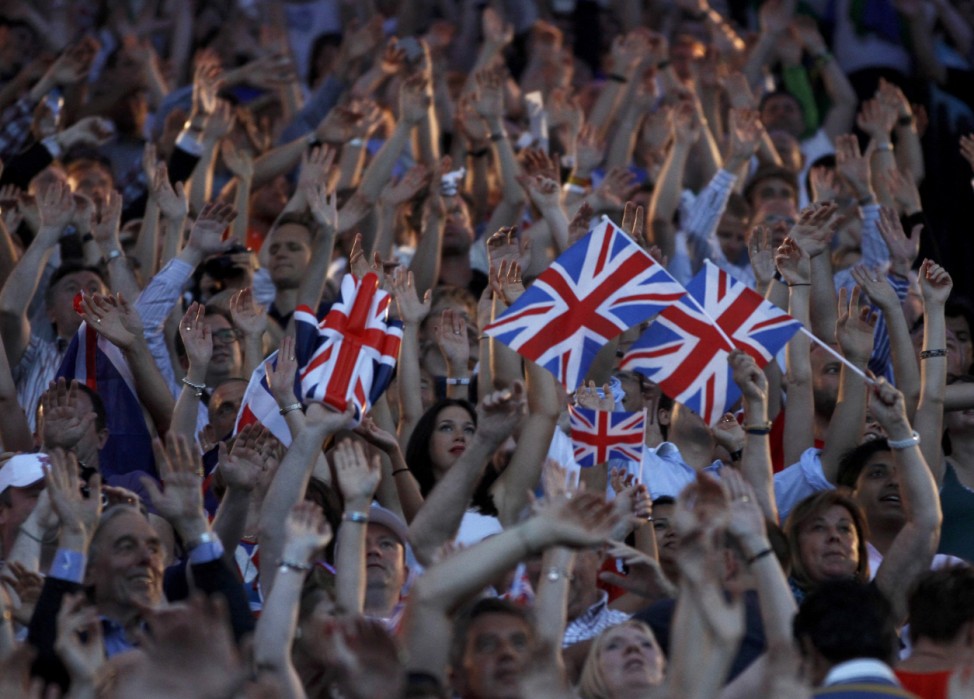Guests stand and wave Britain's flag during the closing ceremony of the London 2012 Olympic Games