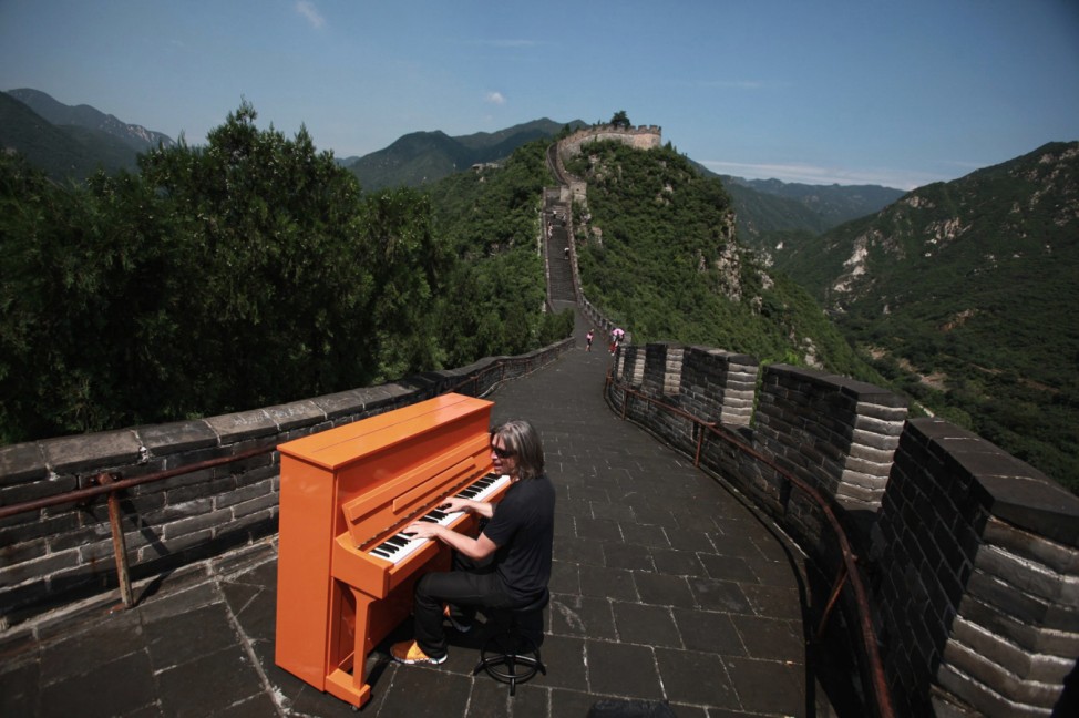 German pianist Stefan Aaron plays his orange piano on the Great Wall in Beijing
