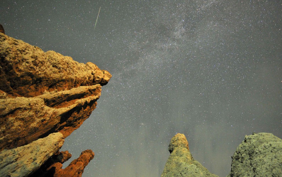 A meteor streaks past stars in the night sky over the village of Kuklici, known for its hundreds of naturally formed stones which resembles human beings, near Kratovo