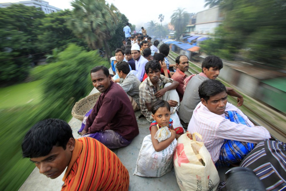 Passengers sit on top of an overcrowded train as it heads for Jamalpur from Dhaka