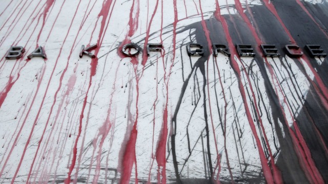 The facade of the Bank of Greece is stained with red paint thrown by demonstrators after a rally in Athens