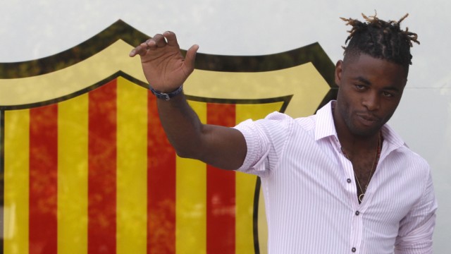 Barcelona's new player Alex Song gestures to photographers after signing for five years at Nou Camp stadium in Barcelona