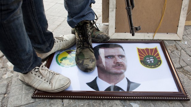 Syrische Rebellen treten in Aleppo auf ein Assad-Porträt