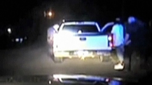Jonesboro Police Department photo taken from video shows police officers questioning and searching occupants of a truck