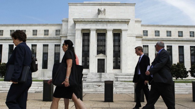 People walk past the Federal Reserve in Washington