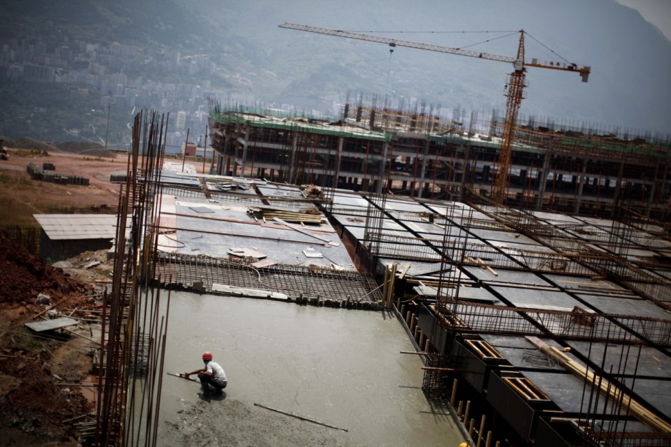 Labourer works at a construction site to raise houses for people who will be relocated in Badong, on the banks of the Yangtze River